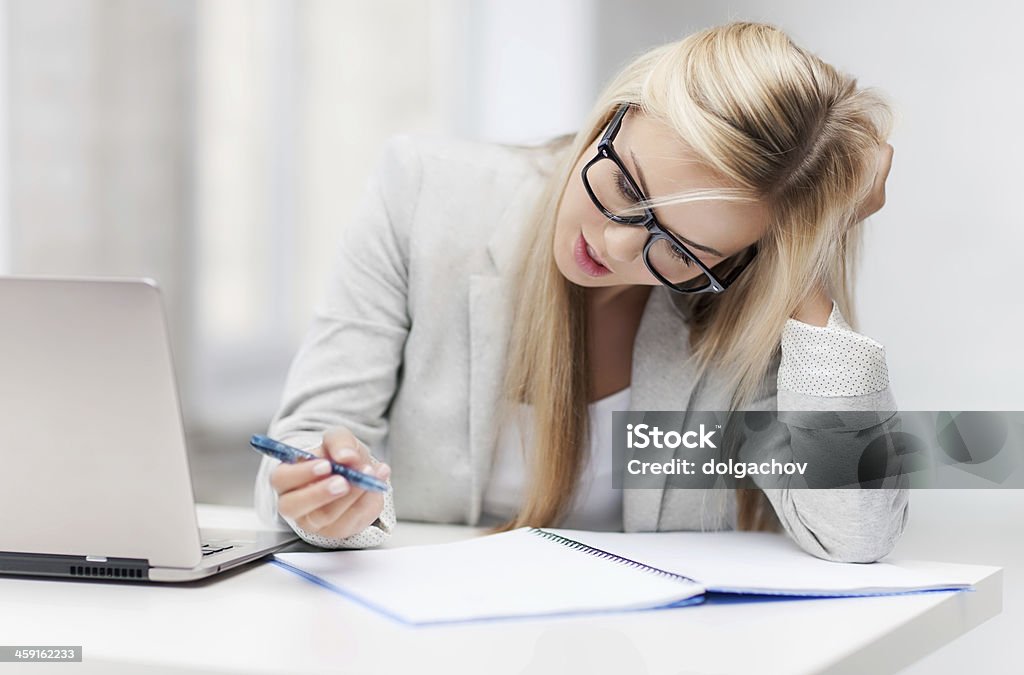 bored and tired woman indoor picture of bored and tired woman taking notes Education Stock Photo