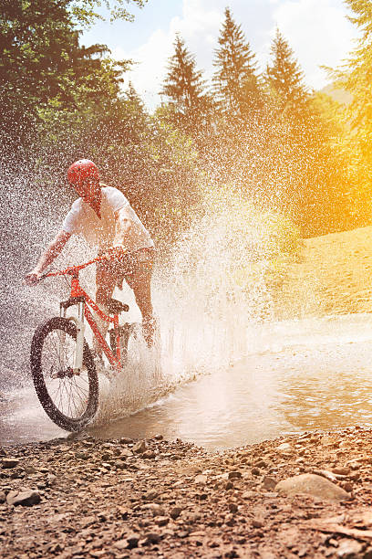 istock Male mountain biker crossing creek. 459163321