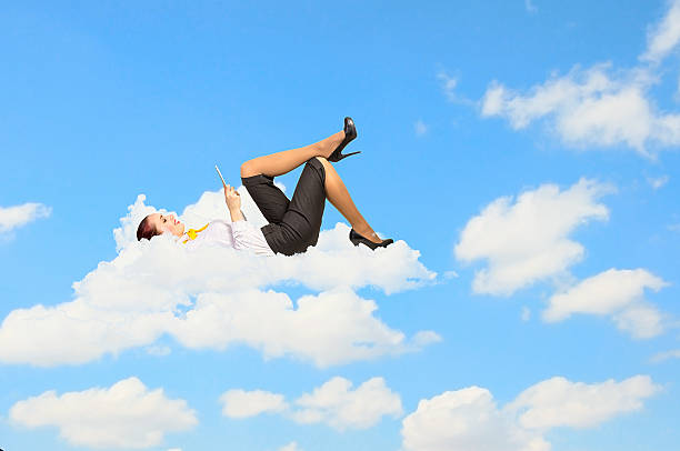 istock Businesswoman lying on clouds 459190345