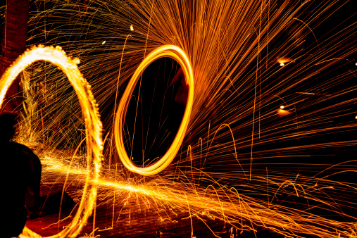 Twirling fire sticks in fire show