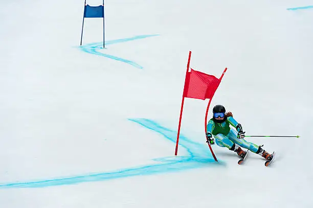 Front view of young female professional skier at giant slalom competition race