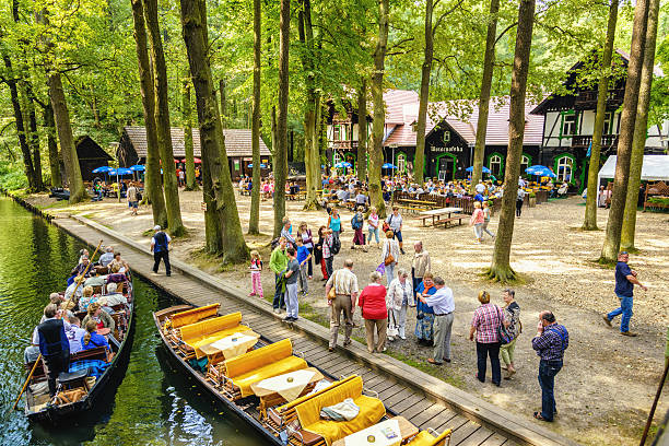 Island and restaurant Wotschofska, Lübbenau (Spreewald) Lübbenau, Germany - August 31, 2013: People arriving with traditional arks at the island and restaurant Wotschafska located in the Spreewald. The restaurant is a major travel destination in the Lübbenau area and a popular stop on river boats tours. The Spreewald forest and wetlands (engl. Spree woods) consists of over 200 small canals and waterways of the river Spree which are cutting their way through meadows, forests and along traditional farmhouses. In 1991 it was designated as biosphere reserve by UNESCO. spreewald stock pictures, royalty-free photos & images