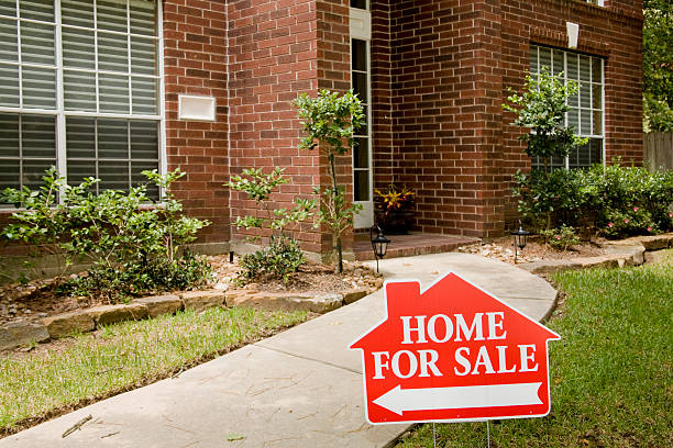 Red brick home for sale in Houston suburbs.  Real estate sign in foreground.