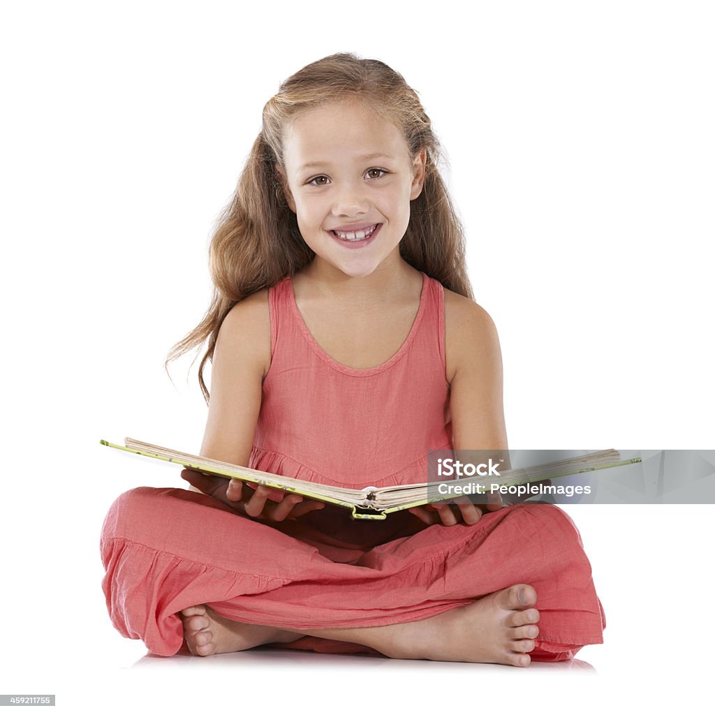 Reading my favourite storybook Studio shot of a young girl reading a storybook White Background Stock Photo