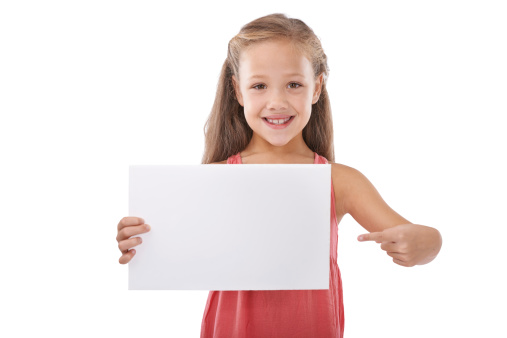 Cropped shot of a cute young girl pointing at a blank card reserved for copyspace