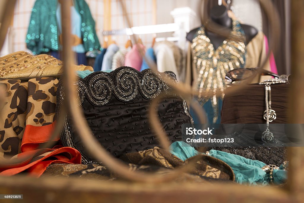 Shopping: Window display in upscale clothing boutique. Evening wear display. Clutch bag, shoes. Clothes rack in background. Black Color Stock Photo