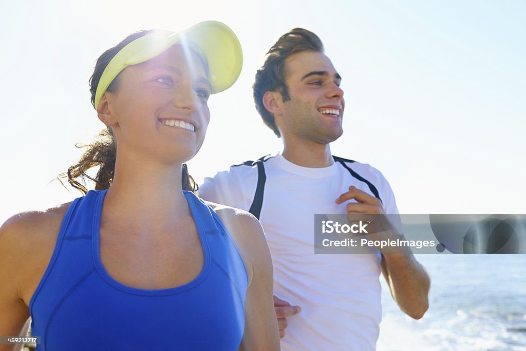 For the love of fitness A young couple running together at the coast 20-24 Years Stock Photo