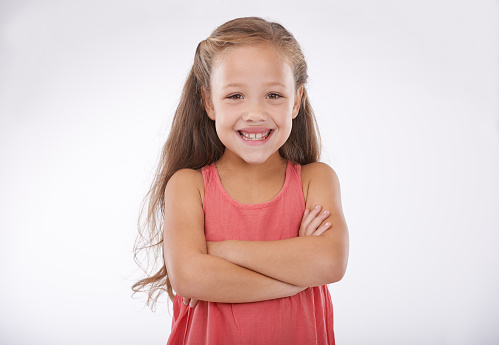 cute smiling little girl in yellow shirt, shorts and gumshoes isolated on white background