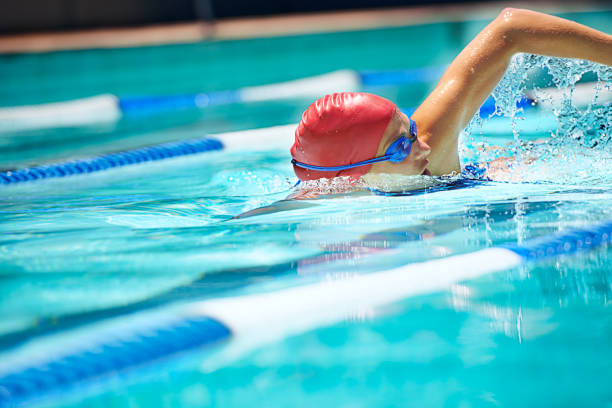 Shot of a professional female swimmer freestyle swimming in her lane