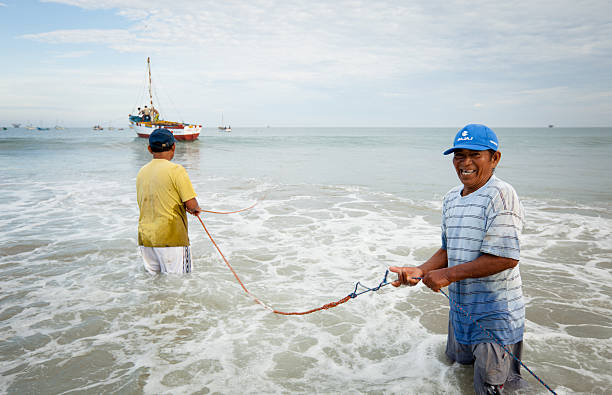 peruvian pescatori che lavorano insieme per trasportare le proprie imbarcazioni in - beach rope nautical vessel harbor foto e immagini stock