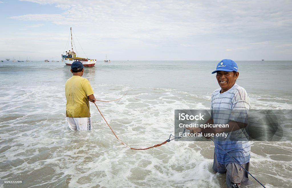 Peruano pescadores trabalhando juntos para levar seus barcos em - Foto de stock de Peru - América do Sul royalty-free