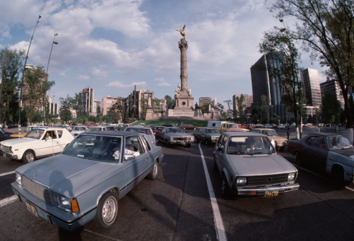Mexico City, Mexico - 7th June 1985: Traffic congestion on the Paseo De Le Reforma with the Angel monument in the background, Traffic exhaust fumes are a major problem in Mexico City.