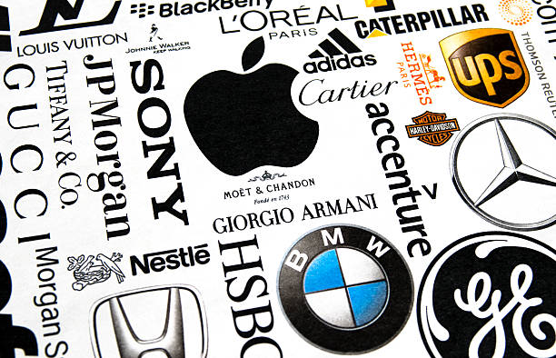 Printed brand names London, England - October 19, 2011: A collection of well-known international brand names printed in a magazine. Names include Louis Vuitton, Johnnie Walker, L'Oreal, Caterpillar, UPS, adidas, Cartier, Apple, Sony, J P Morgan, Tiffany + Co, Gucci, Nestle, Moet et Chandon, Moet + CHandon, Hermes, BMW, Giorgio Armani, Accenture and Harley Davidson. Paper texture and slightly off-set registration visible, with differential focus. moet chandon stock pictures, royalty-free photos & images