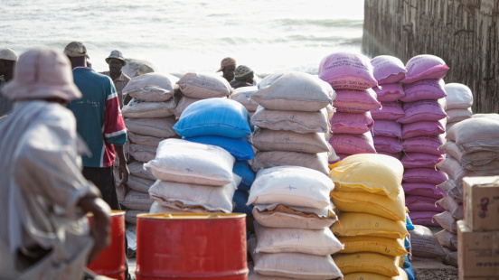 Barra, The Gambia, March 3rd 2011: Local people trading different goods (rice, onions etc) on pier, port of Barra. It is the main crossing point of river Gambia.