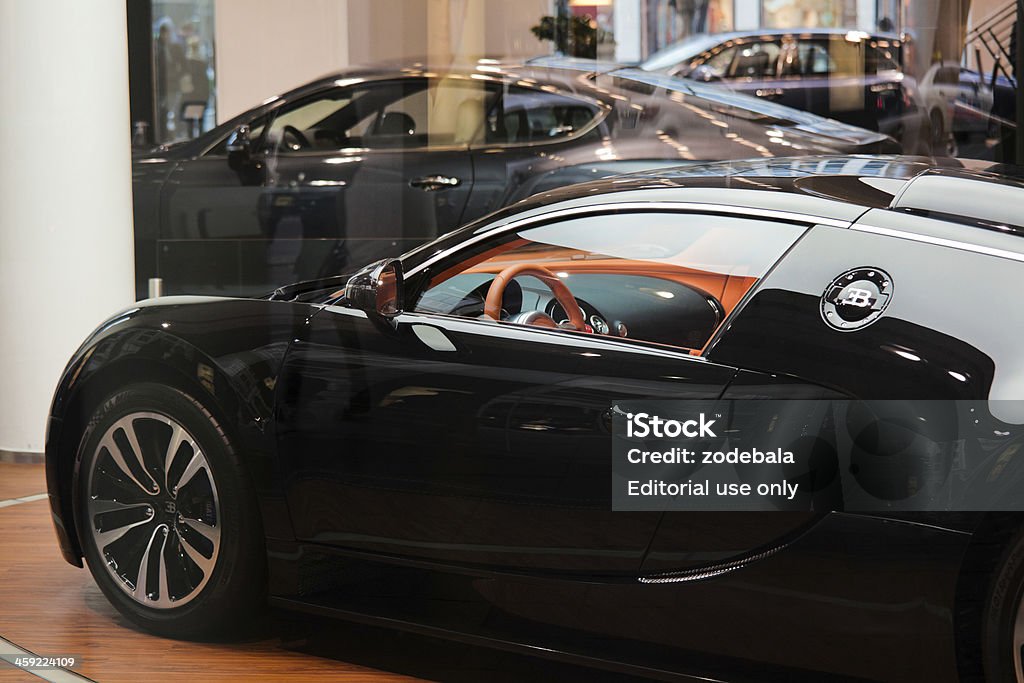 Bugatti Veyron and Luxurious Cars on a Showroom Berlin, Germany - November 17, 2011: A black Bugatti Veyron 16.4 and other luxury cars on a showroom in the city center. The Bugatti Veyron 16.4 is a mid-engined grand touring car. The Super Sport version is the fastest road-legal production car in the world, with a top speed of 431km/h. Car Stock Photo