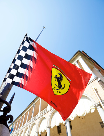 Faenza, Italy - August 21, 2011: Close up to the famous Ferrari logo on red flag in the  Faenza square in Italy. Ferrari is an italian luxury sports car manufacturer based in Maranello, Modena.