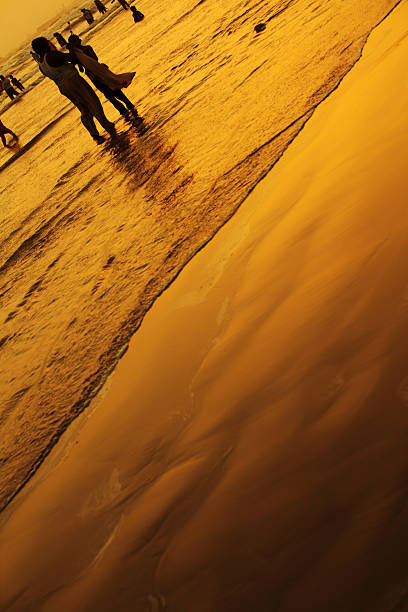 Karachi, Pakistan - May 22, 2010: Karachiites cooling down the warm day at Clifton Beach in Karachi, Pakistan. Clifton beach a.k.a Seaview is most popular local silver sand beach in Karachi visited by thousands of visitors every day. Camel and horse rides along the beach are very popular with tourists.