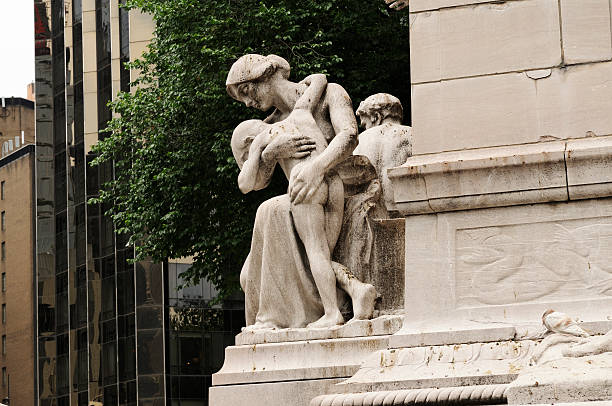 Statue of Mother Consoling Son at Merchant's Gate New York, United States of America - June 5, 2011: Marking the entrance of Central Park's Merchant's Gate is the USS Maine Monument. A woman holding a young nude boy is one of several sculptures created by Attilio Piccirilli in the early 1900s to commemorate the death of 260 American sailors. merchants gate stock pictures, royalty-free photos & images