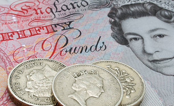 Fifty Pound note and coins Aberdeen, Scotland - April 4, 2009: English fifty pound note and some one pound coins, close up, showing the face of Queen Elizabeth II. elizabeth ii photos stock pictures, royalty-free photos & images