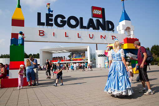 Billund, Denmark - August, 02th 2011: The Legoland sign and logo over the entrance in Billund, Denmark. A tourist is getting directions from an employee.