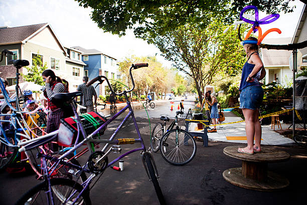 Portland, Oregon, USA - August 28, 2011: A group of cyclists and other people from the neighborhood gather with bikes to watch the passing cyclists and sidewalk musicians during Portland Sunday Parkways.  It is a free summertime event that occurs on two Sundays in Portland.  It was formed to promote healthy active living and as an opportunity to meet neighbors.  A route through neighborhood streets is open to people, walking, cycling, and rolling and other forms of active transportation.