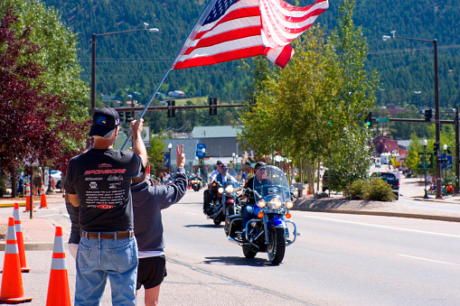 Woodland Park, Colorado, USA - August 20, 2011: Bikers ride westward on highway 24 in Woodland Park Colorado as part of a motorcycle parade to kick off the 19th annual Salute to American Veterans Rally