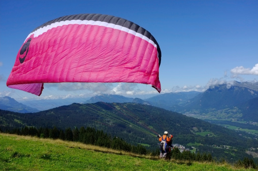Samones, France - August 16, 2011: Paragliding over the French Alps. Paragliding is a free flying sport where the pilot launches themselves by foot.