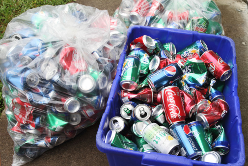 West Palm Beach, USA - August 31, 2011: Aluminum soda cans are being stored for recycling. Two bags and a bin of cans contain a variety of brand sodas, including Coca Cola, Pepsi, Sprite, Dr Pepper, Mountain Dew and Mist.