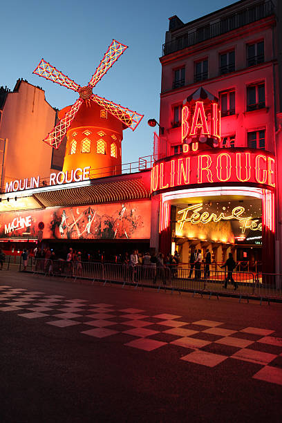 Le Moulin Rouge at the dusk Paris, France - July 31, 2011: Le Moulin Rouge(Red Mill) is a cabaret built in 1889. It\'s situated near Montmartre in the district of Pigalle in the 18th arrondissement of Paris. On this picture le moulin rouge is at the dusk with people waiting in line for this cabaret.  place pigalle stock pictures, royalty-free photos & images