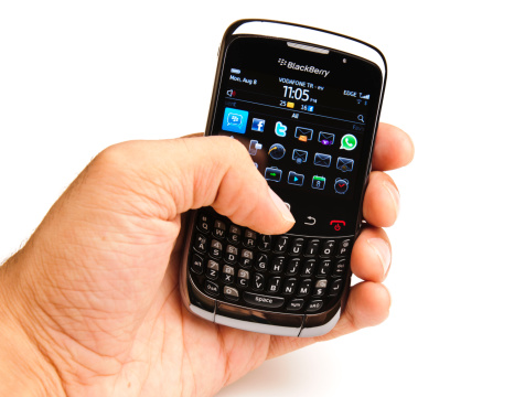 Istanbul, Turkey - August 08, 2011: A male hand holding a Blackberry Curve 3G 9300 smartphone isolated on white background. BlackBerry is a line of mobile e-mail and smartphone devices developed and designed by Research In Motion since 1999.