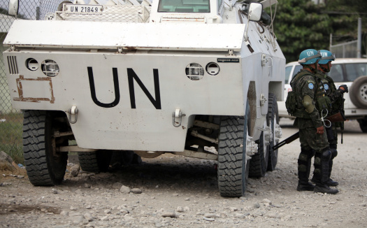 Port-Au-Prince, Haiti - February 6th, 2010: Brazilian UN soldiers stand guard besides a UN tank in a United Nations camp. The UN has sent many soldiers, relief aid and relief aid workers to help the people of Haiti. The 2010 Haiti earthquake was a catastrophic magnitude 7.0 Mw earthquake which caused massive destruction in Haiti.