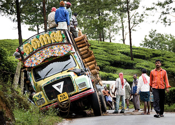 Kochi, Kerala, India - Nov 29, 2008.  A group of men attempt to manually pull a log transport truck out of the ditch.