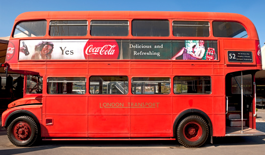 Istanbul, Turkey - October 05, 2011: Side view of classical English-London double-decker buslocated in KoA Museum's garden on the Golden Horn in Istanbul and Coca-Cola advertisement located on the upper part of this area.