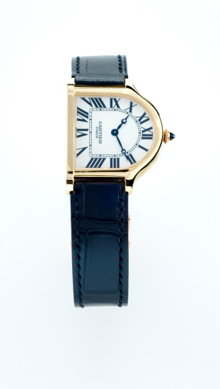 Leiden, The Netherlands - October 11, 2007: Product shot of a Cartier Cloche Collection Privee wristwatch on white background. This watch has a gold case and an alligator leather strap. Only one hundred watches were produced, which makes it very exclusive