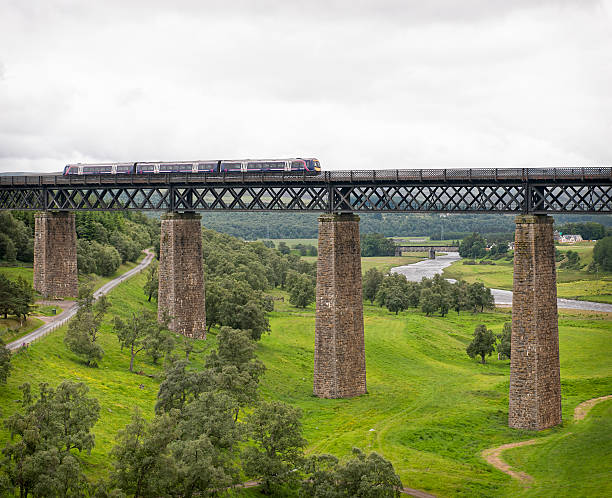 Aviemore, Scotland - 11th July 2011: A ScotRail passenger train, operated by the FirstGroup transport company, crossing a bridge over the River Findhorn, near Aviemore in the Scottish Highlands.