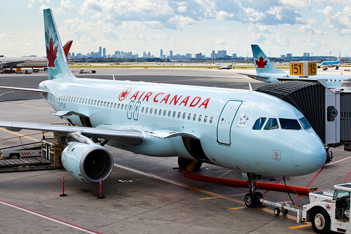 Toronto, Ontario, Canada - August 29, 2011: At Toronto Pearson International Airport, a commercial, Air Canada jet is being loaded and prepped for departure.  Doors open on aircraft ready to loading baggage.