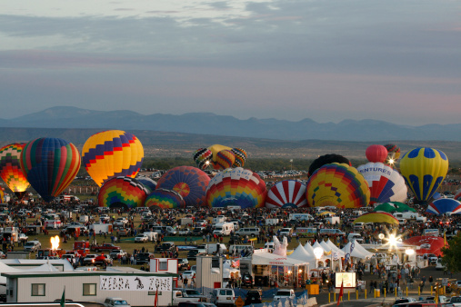 Albuquerque, USA - October 12, 2007: Mass ascension of hot air balloons and crowd of people in the early morning at Balloon Fiesta Park. The Albuquerque International Balloon Fiesta is a world-renowned attraction with over 600 balloons and crowds for some events in excess of 100,000 people.