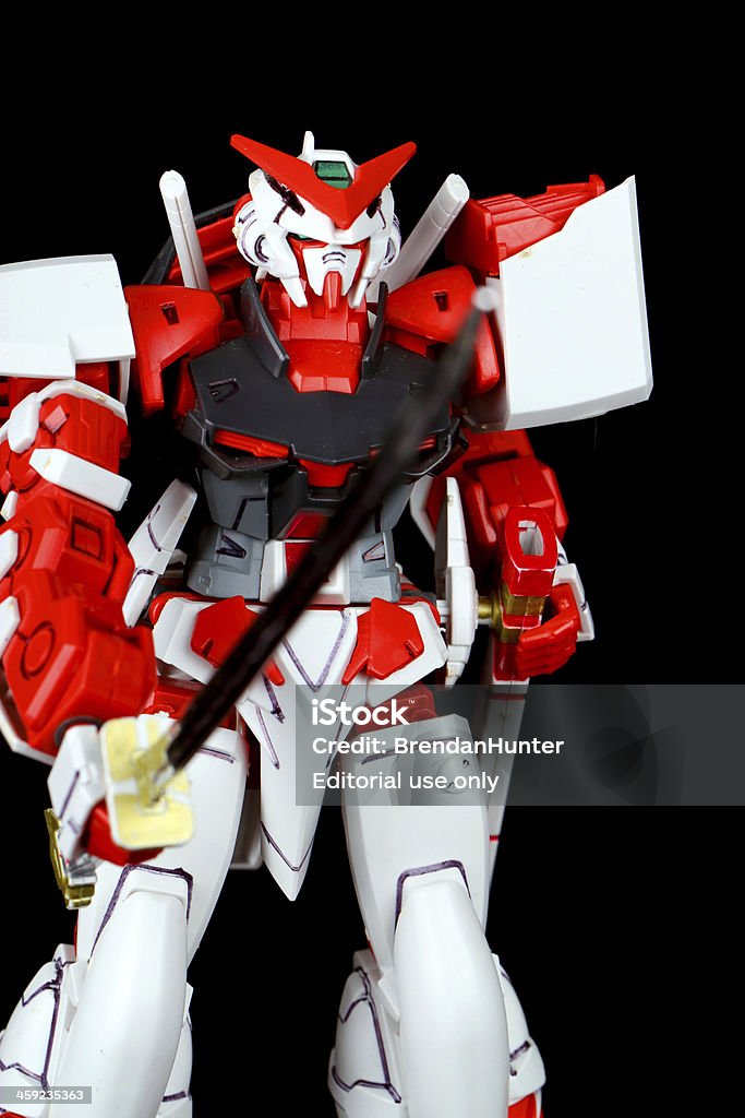 Charging Machine Vancouver, Canada - April 2, 2013: A model of the MBF-P02 Gundam Astray Red Frame Mecha from the Gundam series of Animated TV shows. The model is posed on a black background and is manufactured by Bandai Armed Forces Stock Photo