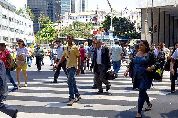 Rio de Janeiro, Brazil - October 11, 2013: Brazilian workers crossing the Rio Branco avenue, one of the most busiest road in Rio de Janeiro downtown. Businessmen and low wealth workers from various ethnicities share the same place of work.