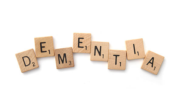 West Palm Beach, USA - October 16, 2013: The word Dementia spelled out in an uneven arrangement of Scrabble letter tiles. Dementia is a medical condition associated with a serious loss of global cognitive ability. A common form of dementia is Alzheimer's disease.