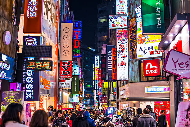 Seoul NIghtlife Seoul, South Korea - February 14, 2013: Crowds pass under the Myeong-Dong neon lights. The location is the premiere district for shopping in the city. seoul stock pictures, royalty-free photos & images
