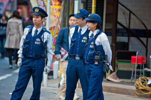 Tokyo, Japan  - November 6, 2010: Japanese Policemen and Policewoman standing on Tokyo Street