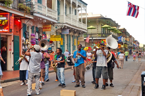 New Orleans, USA - August 7, 2013: In New Orleans on Bourbon St. on August 7, 2013 a jazz band plays jazz melodies in the street for donations from the tourists and locals passing by on this hot summer evening.