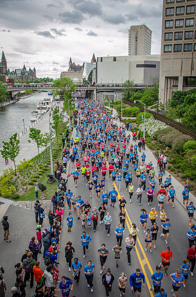 Runners on Colonel By Drive during Ottawa Race Weekend Ottawa, Сanada - May 25, 2013: Athletes running down Colonel By Drive along the Rideau Canal during the Ottawa Race Weekend 5km run  fairmont chateau laurier stock pictures, royalty-free photos & images