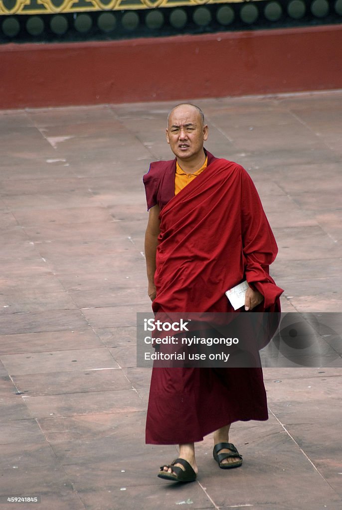 Monk, Rumtek, Sikkim, India Rumtek, India - October 1, 2013: Kagju.order monk in the Rumtek monastery in Sikkim. The Kagju is called the black hat order, is one of the main six Buddhist orders in Tibetan Buddhism. It is headed by the Karmapa. Sikkim, once an independent kingdom, now is part of India, but Tibetan influence is still very strong. Monks are living in the monastery and obey the rules of monastic life. Architect Stock Photo