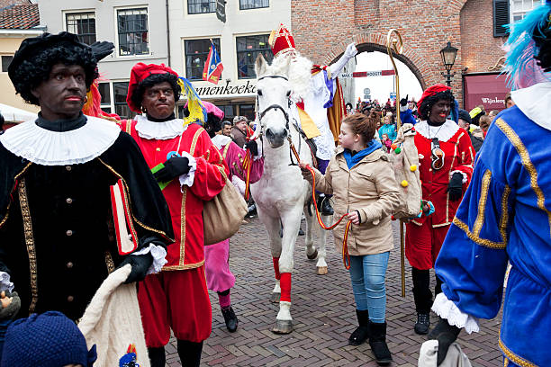 Arrival of Sinterklaas # 11 XL Zaltbommel, the Netherlands - November 16, 2013: The arrival of Sinterklaas in the city of Zaltbommel. Sinterklaas and Zwarte Pieten walking in the streets of Zaltbommel. On the picture Sinterklaas on his horse has just arrived by boat from Spain, together with his helpers called Black Petes. Sinterklaas is a winter holiday figure, it's believed that Sinterklaas brings children presents in the evening of the fifth of December. The arrival of Sinterklaas is always somewhere mid november and also celebrated in many places throughout the country. zwarte piet stock pictures, royalty-free photos & images