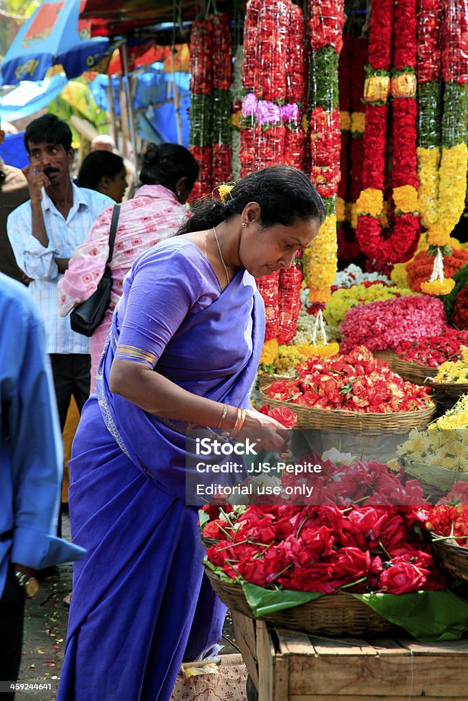 Woman wearing sari picking flowers, market, Bangalore, Karnataka State, India Bangalore, India - November 15, 2008: Woman wearing sari picking flowers at small flower, fruit & vegetable market nearby Sri Lakshmi Narasimha Swami Temple at Nala Bazaar, Secunderabad, Bangalore, Karnataka State, INDIA. Adult Stock Photo