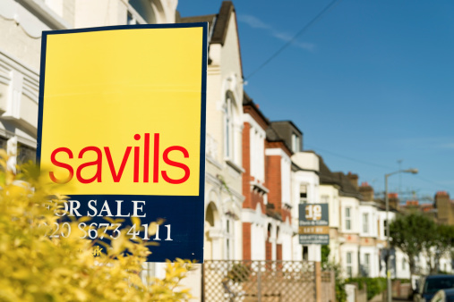 London, UK - September 5, 2012: A Savills sign advertising a residential property for sale on a street of Victorian terraced houses in South London.