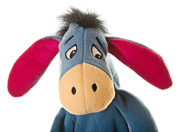 Eeyore Donkey from Winnie-the-Pooh "Albuquerque, USA - May 16, 2012: Studio shot of Eeyore the Donkey stuffed toy, a popular character from Winnie-the-Pooh childrens books. He is  a pessimistic, gloomy, depressed, anhedonic, old grey stuffed donkey who is a friend of Winnie-the-Pooh." winnie the pooh photos stock pictures, royalty-free photos & images