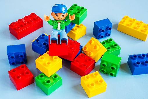 Borgosesia, Italy - January 5, 2013: Happy lego man sit on top of bricks made with Lego construction blocks Duplo series.